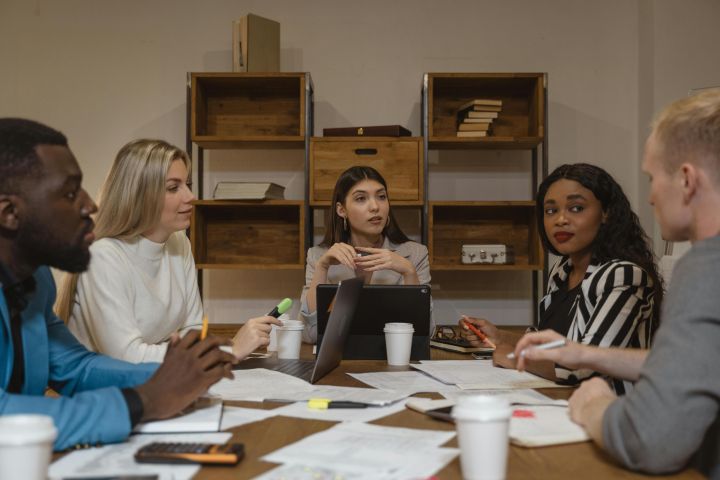A multicultural group of professionals discussing strategies in a modern office setting.