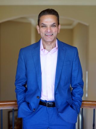 Portrait of a happy man with arms crossed, exuding confidence and friendliness.